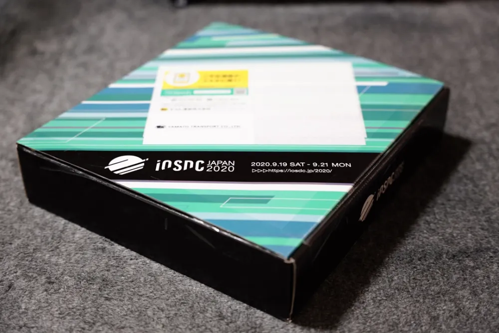 ノベルティが詰まった、ノベルティボックス。iOSDC 2020のサイトデザインに準拠したボックスデザインになっており、めちゃくちゃ格好いい。